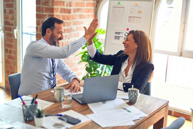 Un uomo e una donna si battono il cinque in un ufficio